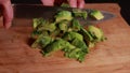 avocado artistry: woman hands cutting avocado on wooden board