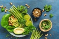 Avocado, asparagus, micro greens, lime, mint,basil, lettuce and cashew nuts. Detox bowl buddha. Blue rustic background, top view.