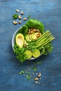 Avocado, asparagus, micro greens, lime, mint, lettuce and cashew nuts. Detox bowl buddha. Blue rustic background, top view. Clean,