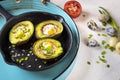 Avocado baked with quail eggs, fresh onion