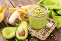 Avocado and banana smoothie with oats with ingredients in glass jar on wooden background Royalty Free Stock Photo