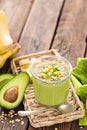 Avocado and banana smoothie with oats with ingredients in glass jar on wooden background Royalty Free Stock Photo