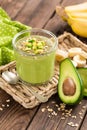 Avocado and banana smoothie with oats with ingredients in glass jar on wooden background Royalty Free Stock Photo