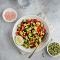 Avocado, black bean, corn and bell pepper salad in white bowl