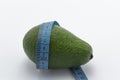 avocado with blue measure tape, health fitness, nutrition, exercise or diet concept, on white background with copy space Royalty Free Stock Photo