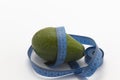 avocado with blue measure tape, health fitness, nutrition, exercise or diet concept, on white background with copy space Royalty Free Stock Photo