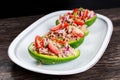 Avocado boats stuffed with tuna, red onion and cherry tomatoes.