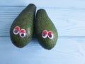 Avocado cartoon eyes on blue wooden creative, tropical