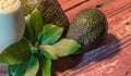 Avocado cream on the wooden surface with fresh fruits and leaves