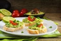 avocado cream or guacamole on baguette sandwiches freshly prepared with ingredients like lemon and tomatoes on a rustic wooden