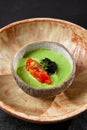 Avocado cream with minced tomato and caviar. Guacamole sauce in handmade ceramic bowl. Modern food - avocado dip. Healthy