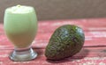 Avocado cream on the wooden surface with fresh fruits and leaves