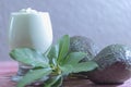 Avocado cream on the wooden surface with fresh fruits and leaves