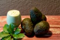 Avocado cream on the wooden surface with fresh fruits and leaves