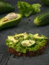Avocado with cucumbers on a piece of bread on a wooden table Royalty Free Stock Photo