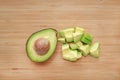 Avocado cut half and chopped on wooden board background Royalty Free Stock Photo