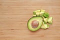 Avocado cut half and chopped on wooden board background with copy space Royalty Free Stock Photo