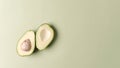Avocado cut in half with a kernel on a pastel green background with a copy of space Royalty Free Stock Photo