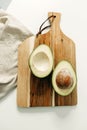 An avocado cut in half lies on the kitchen board Royalty Free Stock Photo