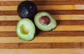 Avocado cut in half with a stone on a wooden board. Royalty Free Stock Photo