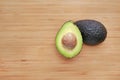 Avocado cut in half on wooden board background Royalty Free Stock Photo