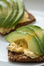 Avocado egg salad on sunflower seed whole grain bread slice with turmeric for breakfast or snack