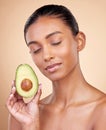 Avocado, facial beauty and woman in studio, background and omega 3 for aesthetic wellness. Face of calm indian female