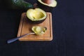 Avocado fruit cut in half on black wood background Royalty Free Stock Photo