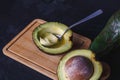 Avocado fruit cut in half on black wood background Royalty Free Stock Photo