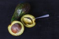 Avocado fruit cut in half on black wood background Royalty Free Stock Photo