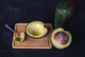 Avocado fruit cut in half on black wood background Royalty Free Stock Photo