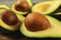 Avocado fruits cut in half, seed visible, close up photo, showing structure on brown pit