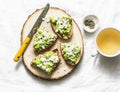 Avocado, goat cheese, grilled ciabatta sandwiches and green tea on light background, top view. Healthy breakfast