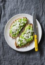 Avocado, goat cheese, grilled ciabatta sandwiches on grey background, top view