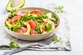 Avocado and grapefruit salad in a white plate on a white background. Royalty Free Stock Photo