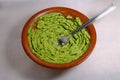 Avocado grinded guacamole on mexican molcajete on colorful background. Mexican food Royalty Free Stock Photo