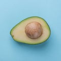 Avocado half with kernel on blue background Royalty Free Stock Photo