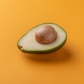 Avocado half with kernel on orange background Royalty Free Stock Photo