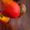 Avocado hass with red pears, ripe mango with water drops on a wooden table close-up, copy space, template Royalty Free Stock Photo