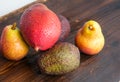 Avocado hass with red pears, ripe mango with water drops on a wooden table close-up, copy space, template Royalty Free Stock Photo