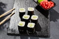 Avocado hosomaki on dark stone table. Hosomaki with avocado. Sushi roll with avocado inside. Style concept japanese menu with