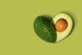 Avocado Isolated on Green background in shape of Heart. Love Symbol or Fresh Organic Fruit for Healthy Lifestyle Concept Royalty Free Stock Photo