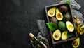 Avocado oil and fresh avocados on a black background. Rustic style. Top view. Royalty Free Stock Photo