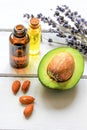 Avocado oil for handmade cosmetics with herb on wooden background