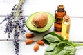 Avocado oil for handmade cosmetics with herb on wooden background