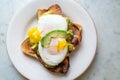Avocado with pouched eggs and bacon on toast