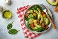 Avocado, red, yellow, black cherry tomato, spinach and cucumber fresh salad with spices pepper and olive oil in grey bowl on grey Royalty Free Stock Photo