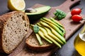 Avocado and rye bread toast on cutting board Royalty Free Stock Photo