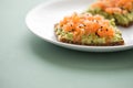 Avocado smoked salmon on sunflower seed whole grain bread slice with sesame seeds for breakfast or snack on mint green background Royalty Free Stock Photo