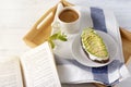 Avocado sandwich and a Cup of black coffee on a tray with a towel, book, Breakfast